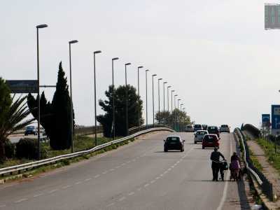 Ci incamminiamo sul cavalcavia e lungo il ponte incrociamo una coppia di rom: lui porta con s� una bici, lei spinge un passeggino, incuranti delle auto che sfrecciano a poca distanza sull'asfalto
